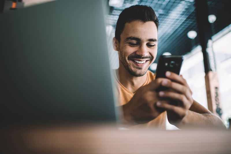 Man using phone while on computer