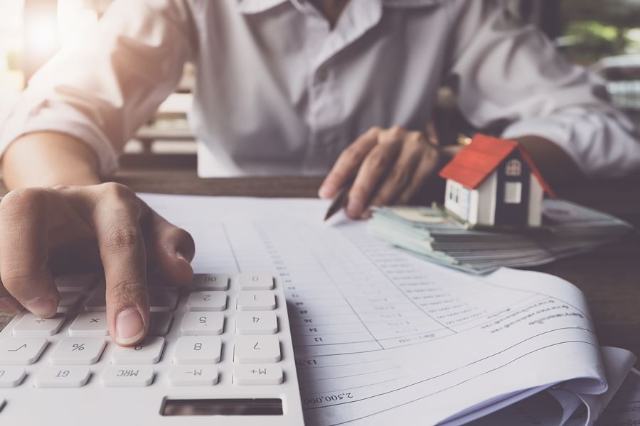 Man using calculator while doing paperwork